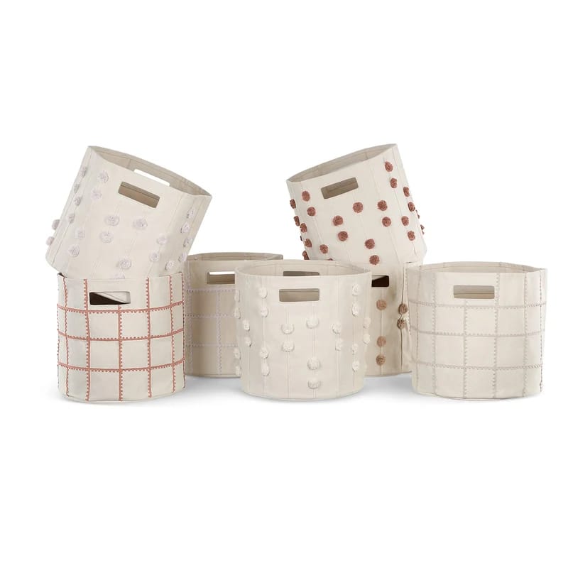 Cream nursery storage basket set with pom-pom and grid details.
